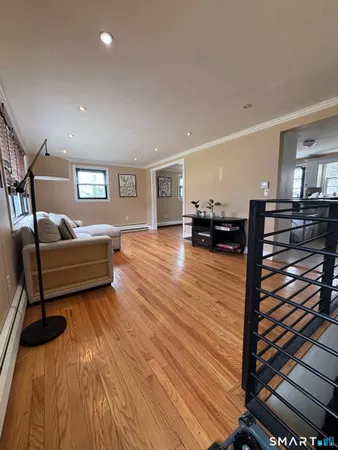 a living room with furniture and a wooden floor