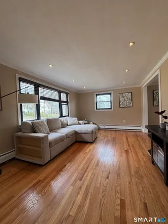 a living room with furniture and a wooden floor