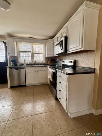 a kitchen with stainless steel appliances granite countertop a sink and cabinets