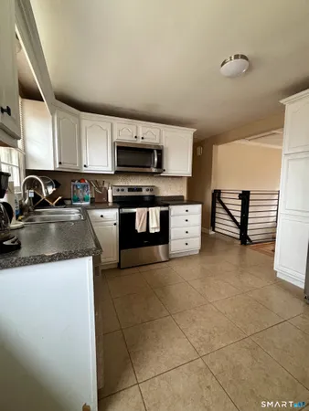 a kitchen with stainless steel appliances a sink a stove top oven a counter space and cabinets