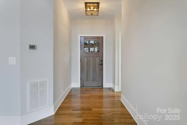 a view of empty room with wooden floor and window