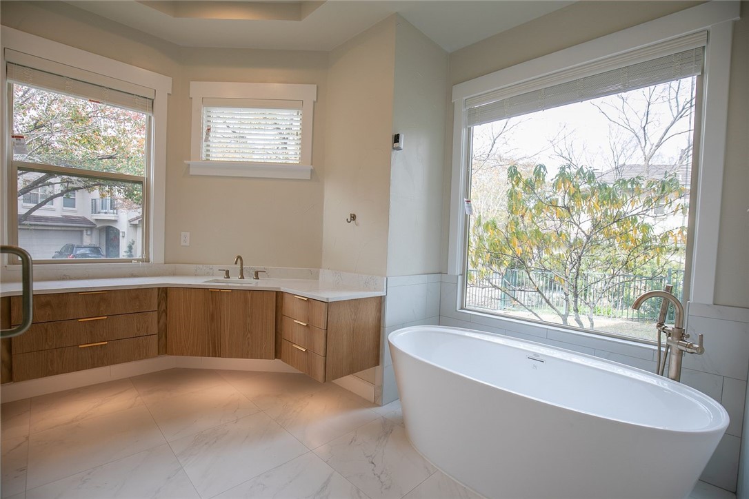 2800 Waymaker Way, Unit 29 Austin, TX 78746 - Photo 13 of 25 a bathroom with a granite countertop sink tub and window