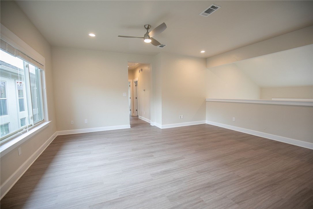 2800 Waymaker Way, Unit 29 Austin, TX 78746 - Photo 16 of 25 a view of an empty room with wooden floor and a window