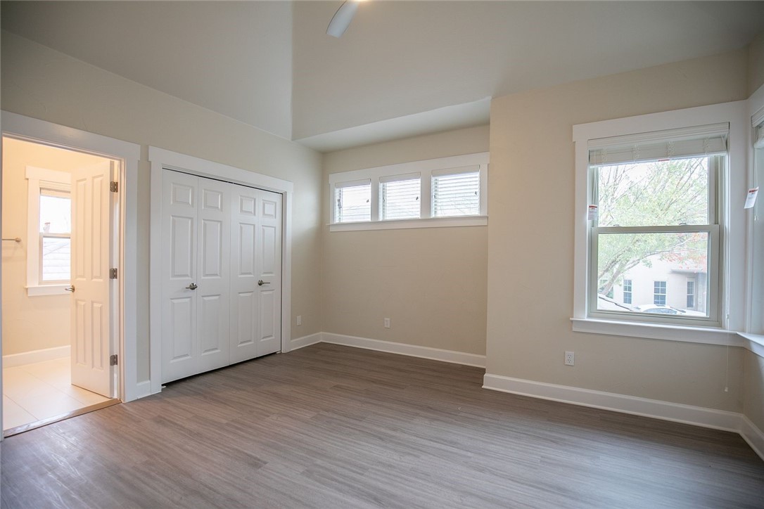 2800 Waymaker Way, Unit 29 Austin, TX 78746 - Photo 17 of 25 an empty room with wooden floor and windows
