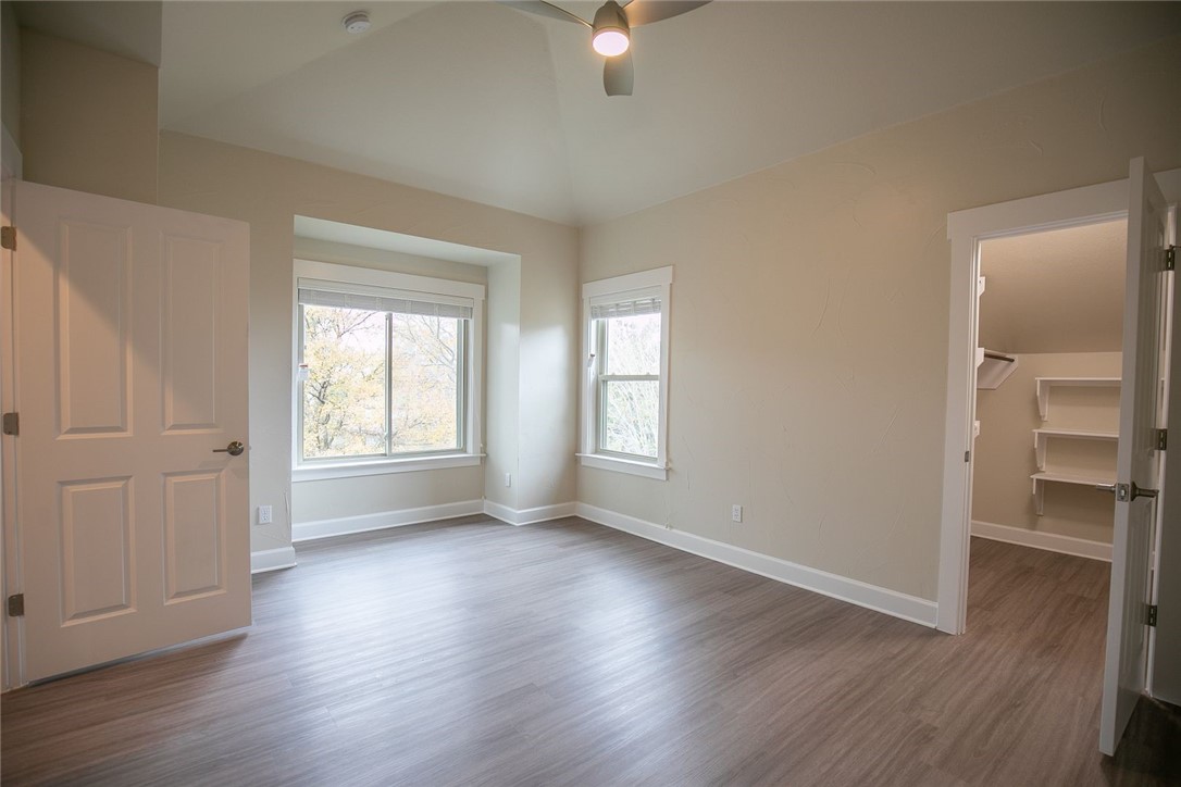 2800 Waymaker Way, Unit 29 Austin, TX 78746 - Photo 23 of 25 an empty room with wooden floor and windows