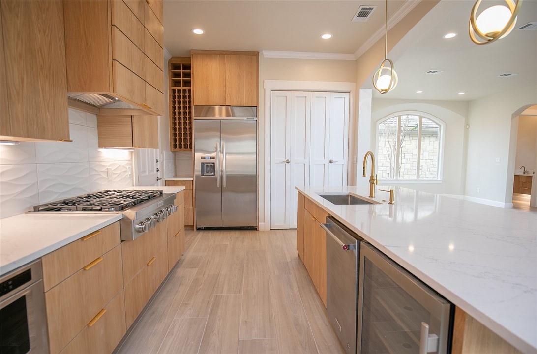 2800 Waymaker Way, Unit 29 Austin, TX 78746 - Photo 4 of 25 a large kitchen with stainless steel appliances granite countertop a lot of cabinets and wooden floor