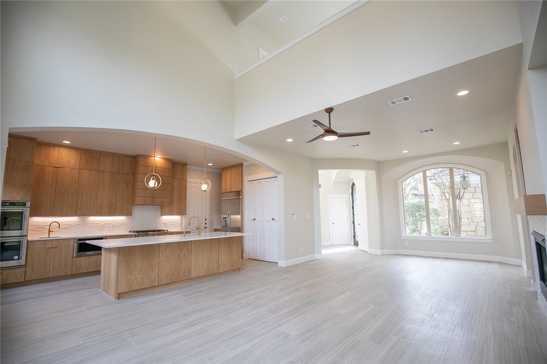 2800 Waymaker Way, Unit 29 Austin, TX 78746 - Photo 6 of 25 a large kitchen with kitchen island a chandelier and wooden floors