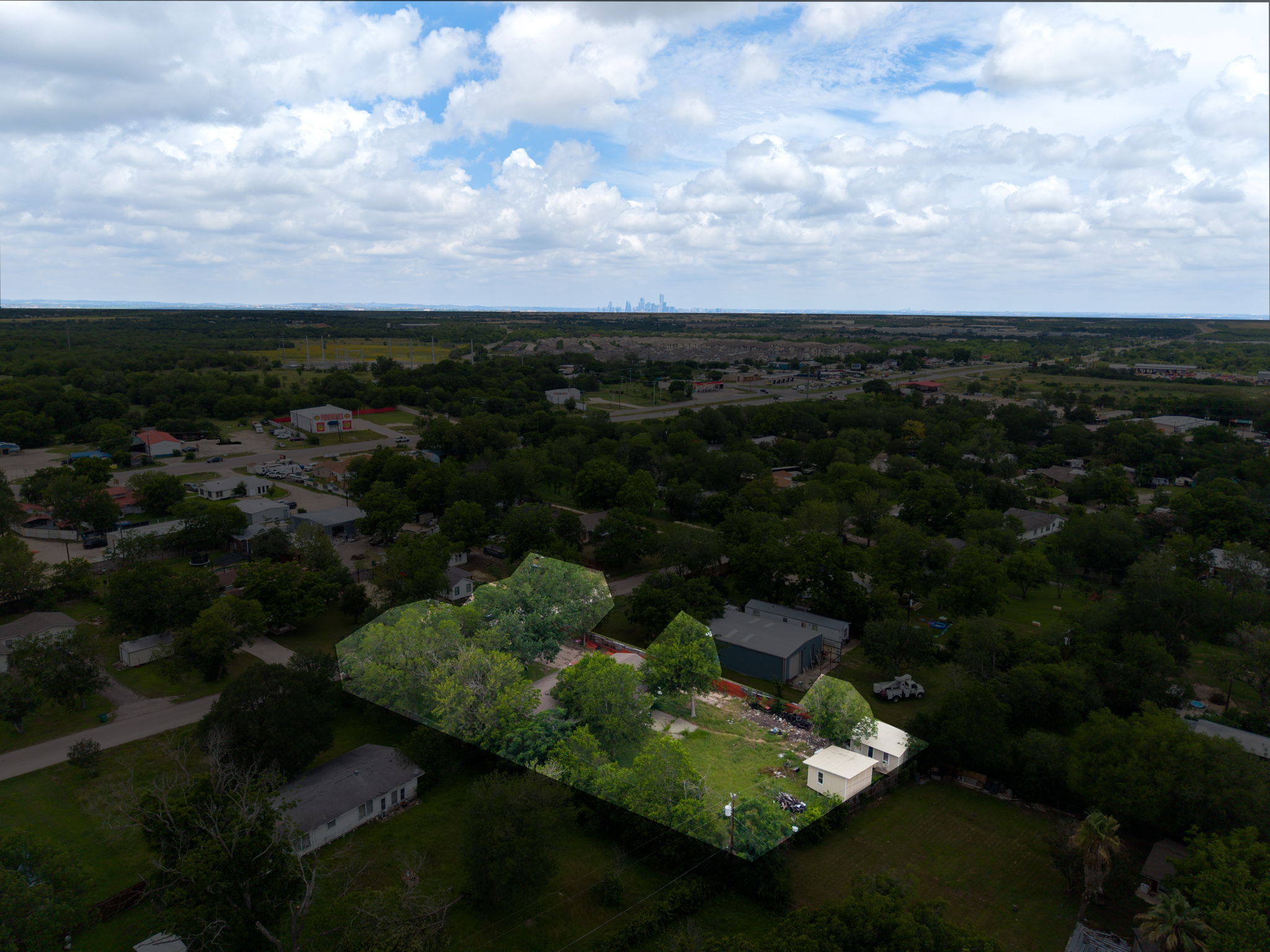 6803 Viewing Place Austin, TX 78719 - Photo 3 of 20 An aerial perspective showcases a spacious lot amidst a verdant landscape with distant city views.