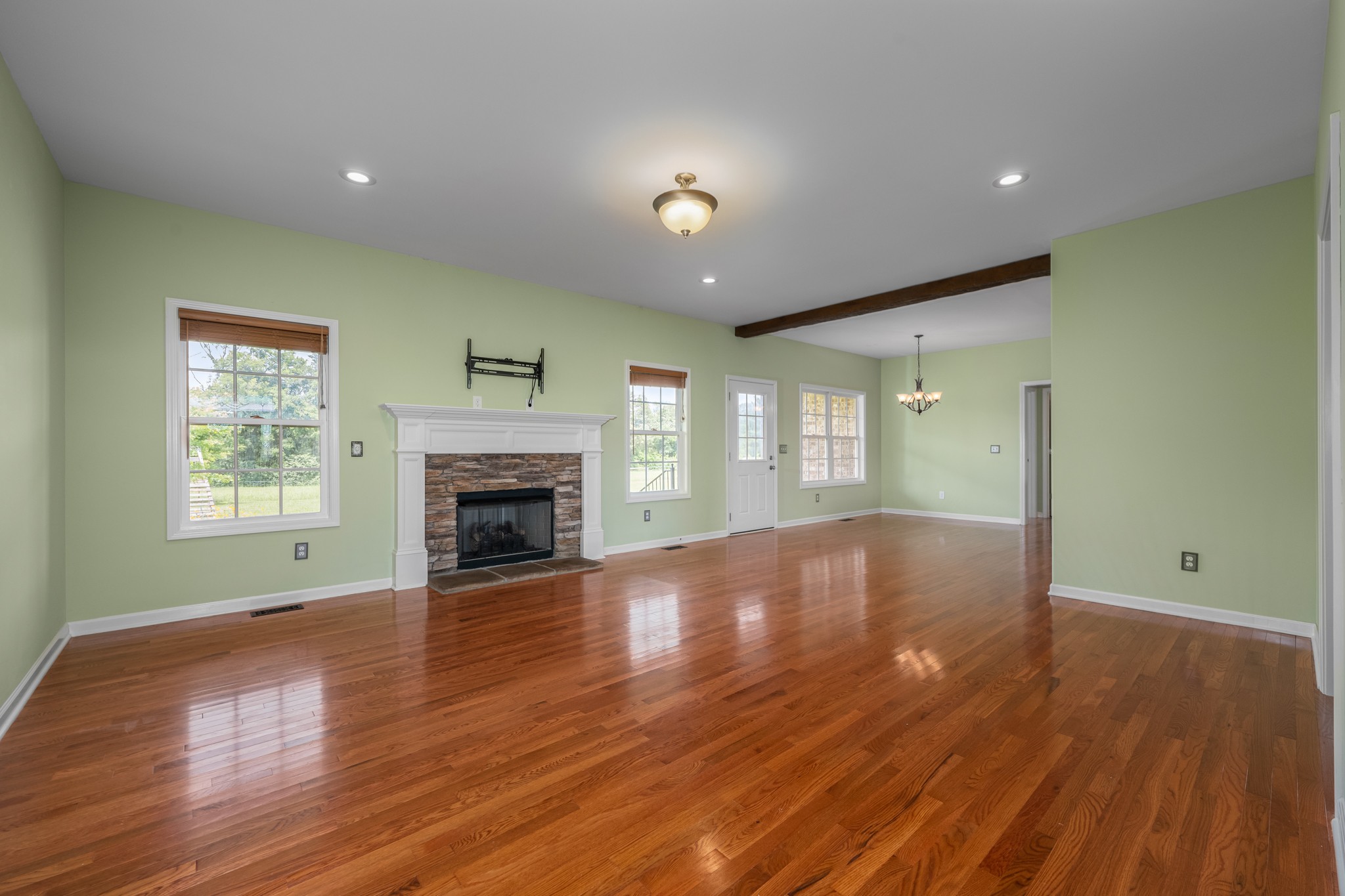 7540 Joe Rowlin Road Christiana, TN 37037 - Photo 5 of 42 an empty room with wooden floor fireplace and windows
