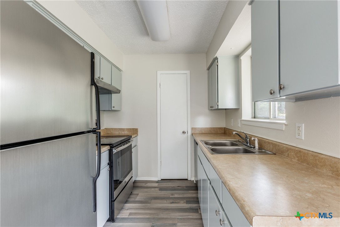 a kitchen with a refrigerator and a stove top oven