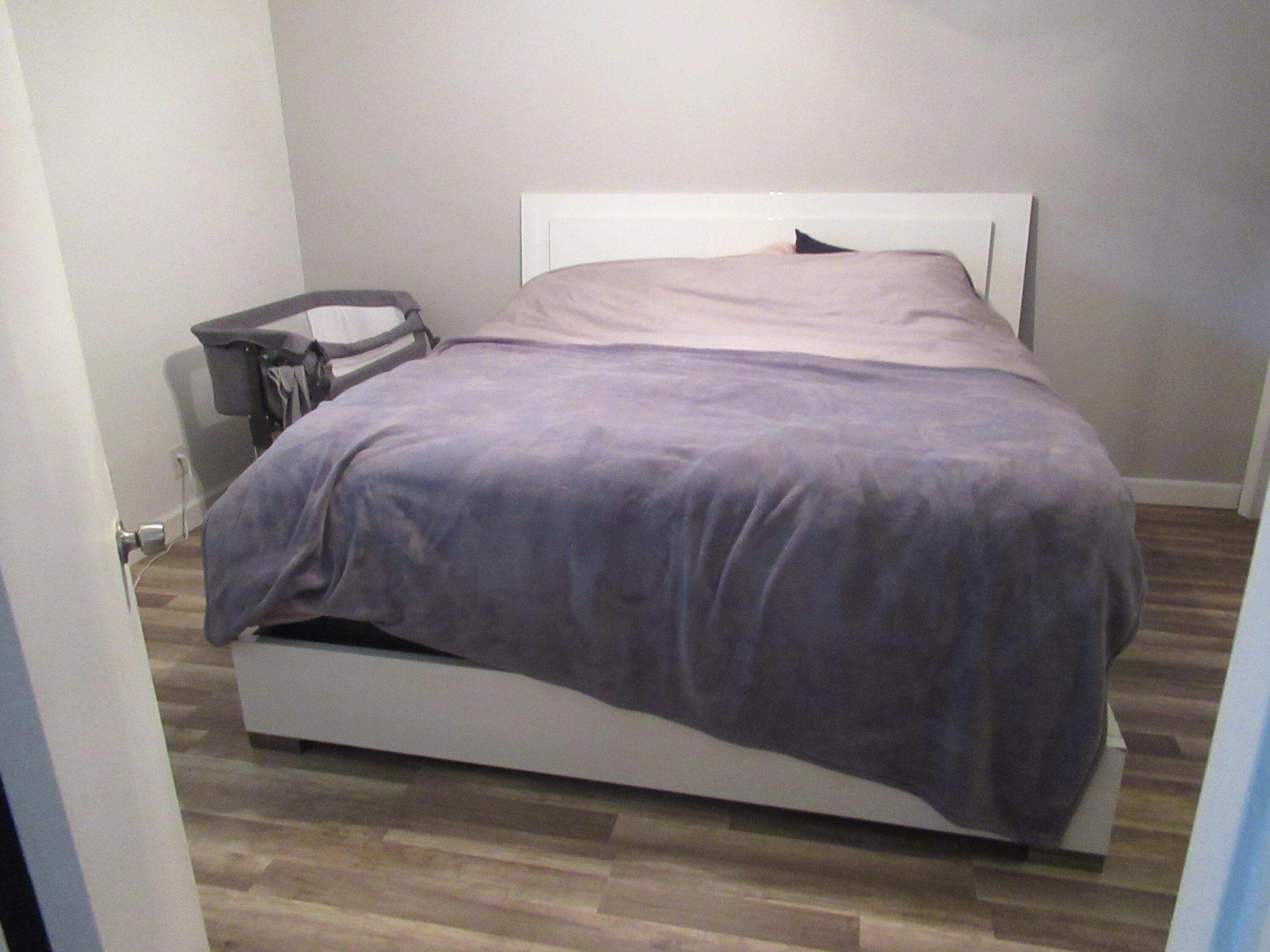 22016 Palms Way, Unit 204 Boca Raton, FL 33433 - Photo 15 of 23 a bedroom with a bed and a wooden floor