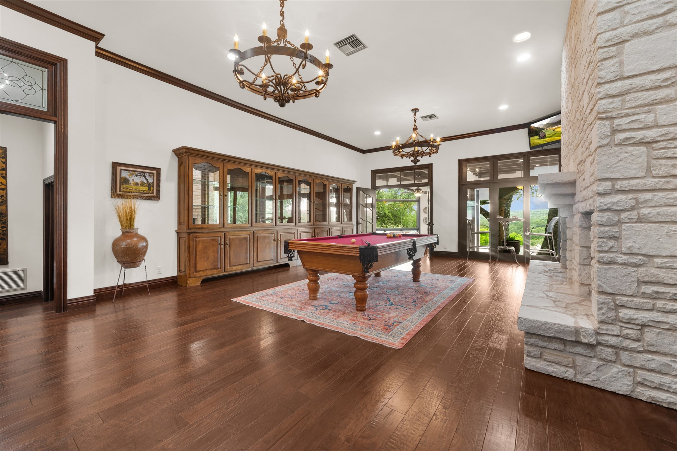 34000 Smithson Valley Road Bulverde, TX 78163 - Photo 15 of 50 Perfect for entertaining, the game room features hardwood flooring, custom built-ins, a pool table, and direct outdoor access. Large windows showcase stunning Hill Country vistas while filling the room with natural light.