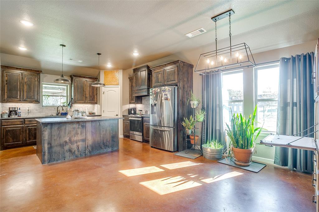 1028 Hope Court Boyd, TX 76023 - Photo 14 of 40 a kitchen with stainless steel appliances granite countertop a refrigerator a sink dishwasher a stove and a dining table with wooden floor