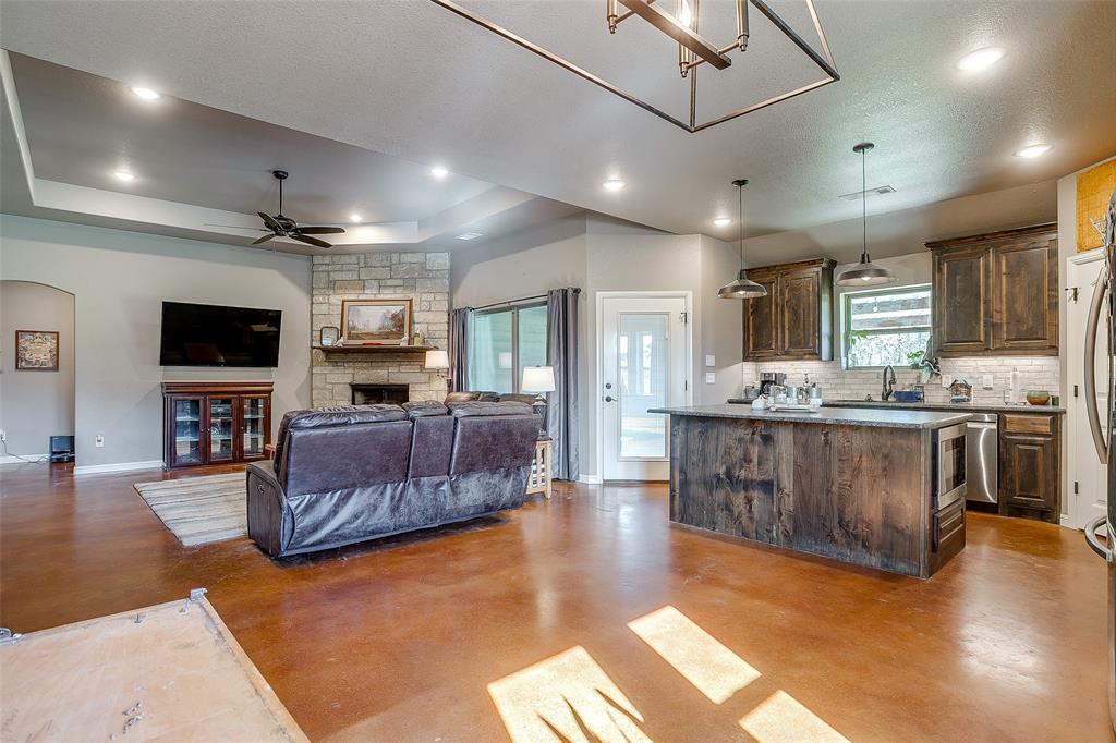 1028 Hope Court Boyd, TX 76023 - Photo 15 of 40 a large living room with stainless steel appliances kitchen island granite countertop a large kitchen island a sink a stove and a refrigerator