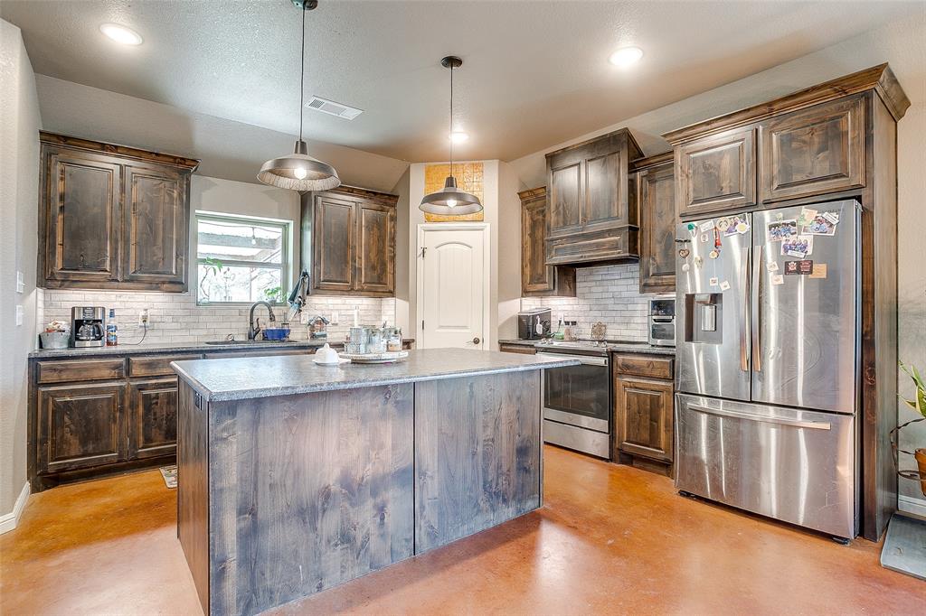 1028 Hope Court Boyd, TX 76023 - Photo 16 of 40 a kitchen with granite countertop stainless steel appliances a sink cabinets and a window