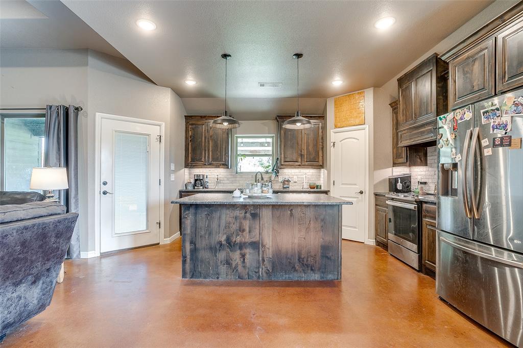 1028 Hope Court Boyd, TX 76023 - Photo 18 of 40 a large kitchen with stainless steel appliances granite countertop a refrigerator a stove and a sink