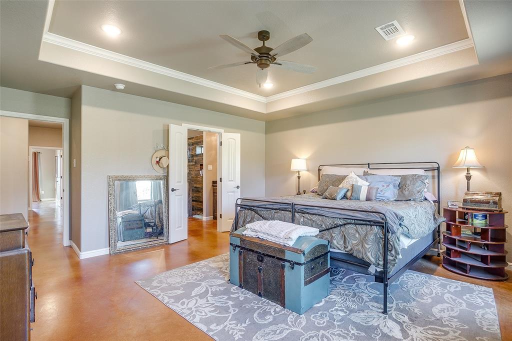 1028 Hope Court Boyd, TX 76023 - Photo 23 of 40 a spacious bedroom with a bed a chandelier and closet