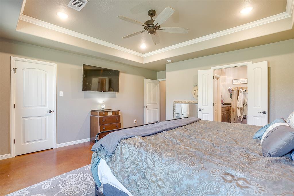 1028 Hope Court Boyd, TX 76023 - Photo 24 of 40 a bedroom with a bed and a chandelier