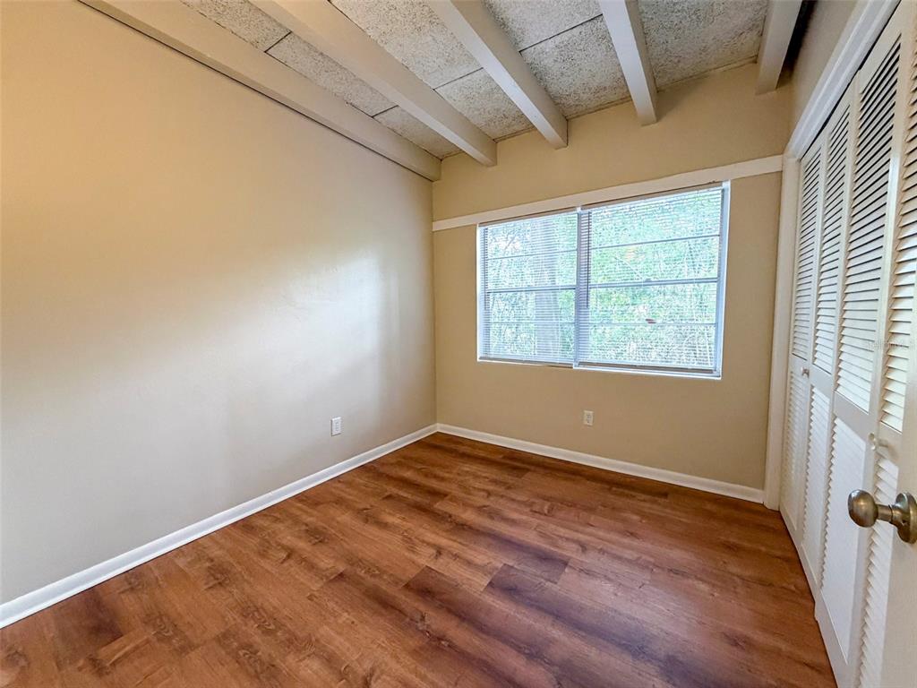 219 Northwest 3rd Avenue, Unit B Gainesville, FL 32601 - Photo 13 of 20 an empty room with wooden floor and windows