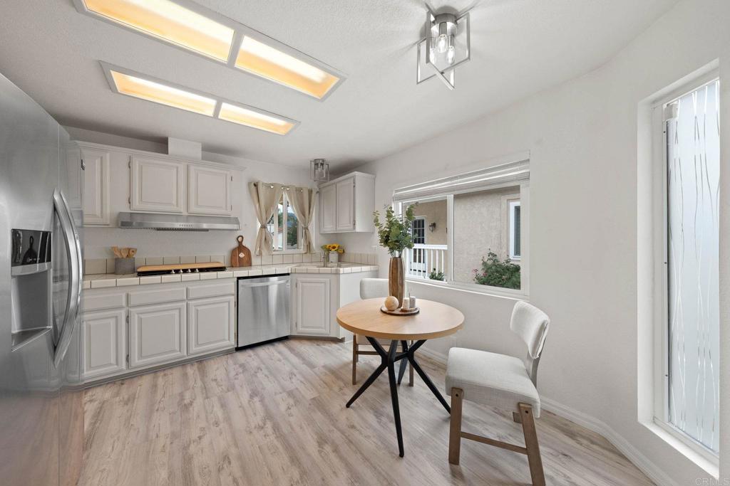 4938 Dulin Road Fallbrook, CA 92028 - Photo 6 of 15 a kitchen with a table chairs a sink dishwasher refrigerator and cabinets