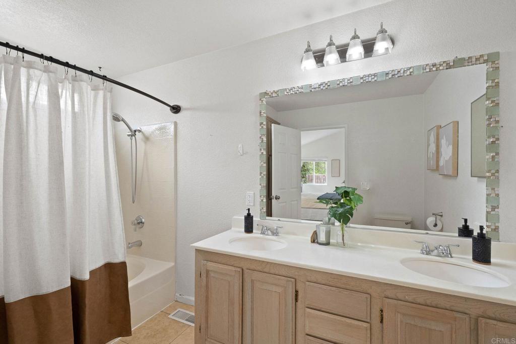 4938 Dulin Road Fallbrook, CA 92028 - Photo 9 of 15 a bathroom with a double vanity sink and a mirror