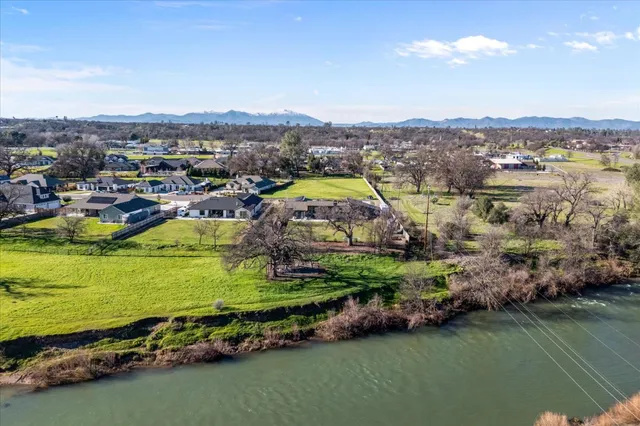 an aerial view of residential houses with outdoor space and river