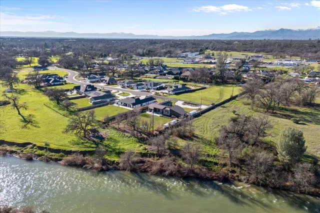 a view of a house with a big yard and large trees
