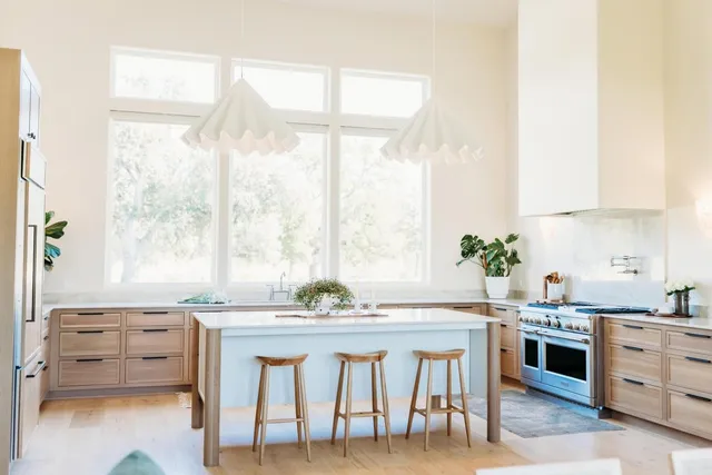 a kitchen with stainless steel appliances a stove and white cabinets