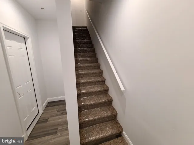 a view of a hallway with wooden floor and entryway