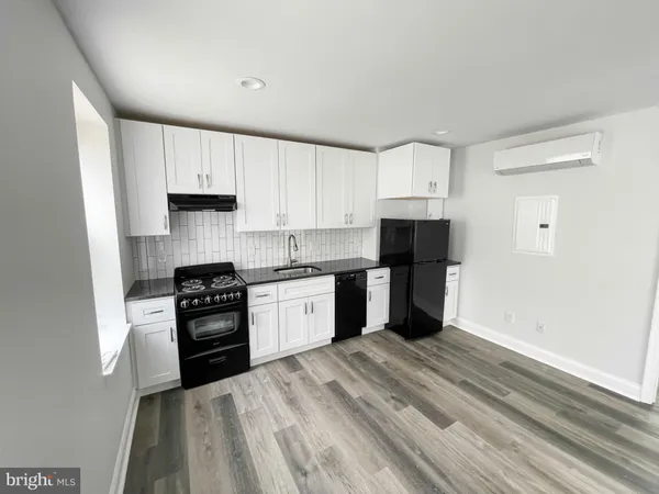a kitchen with granite countertop a refrigerator stove top oven and sink