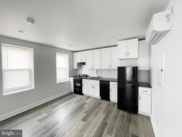a kitchen with granite countertop a refrigerator stove top oven and sink