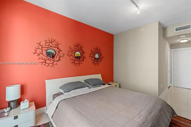 a bedroom with a bed and a wall painting