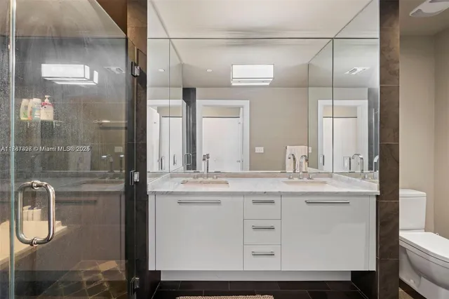 a bathroom with a sink a toilet and shower