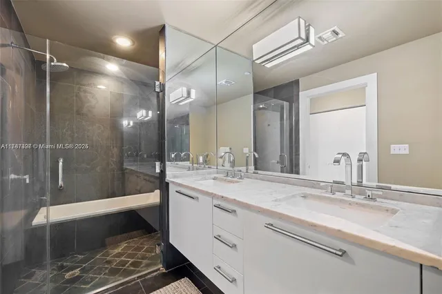 a bathroom with a double vanity sink mirror and shower