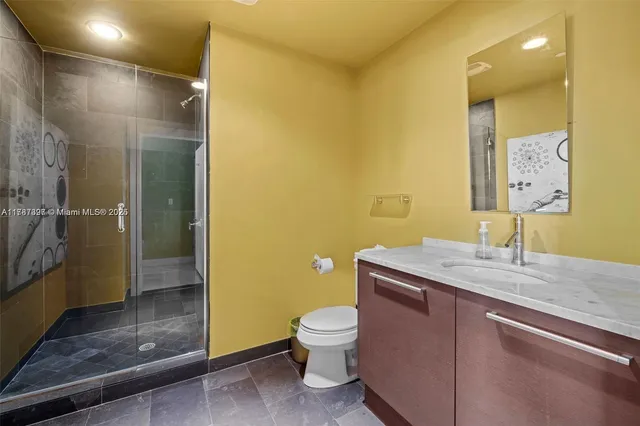 a bathroom with a granite countertop sink toilet and shower