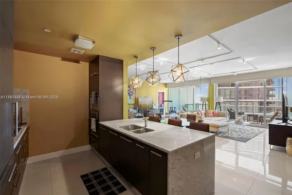 a kitchen with granite countertop a sink and a refrigerator