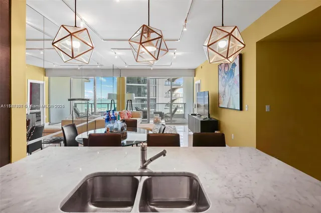a living room with couch a dining table and a chandelier