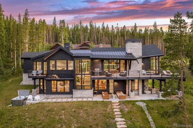 a view of a big house with pool and chairs