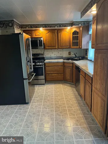 a kitchen with stainless steel appliances granite countertop a refrigerator and a stove top oven