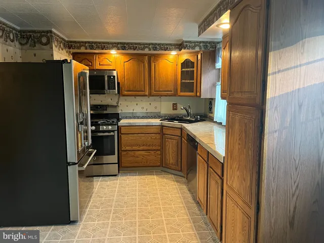 a kitchen with stainless steel appliances granite countertop a stove microwave and refrigerator