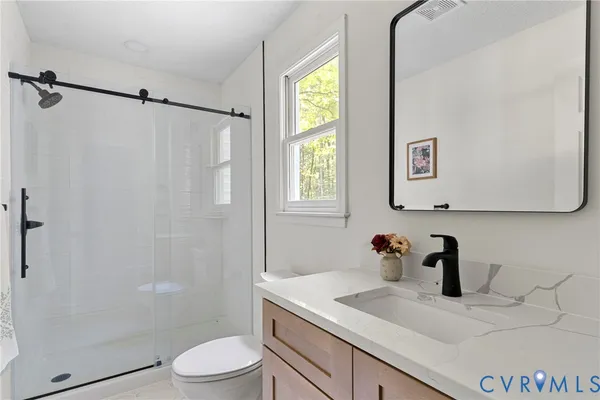 a bathroom with a sink a toilet and shower