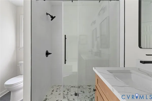a bathroom with a sink a toilet and shower