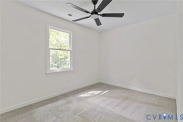 an empty room with a window and a fan