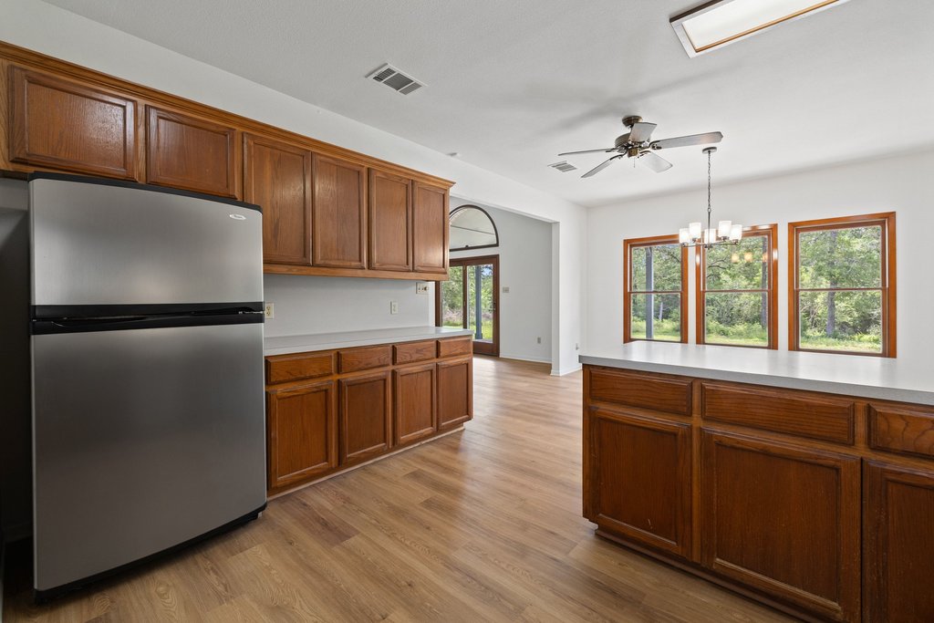 244 Woodway Elgin, TX 78621 - Photo 15 of 40 a kitchen with granite countertop wooden floors and stainless steel appliances