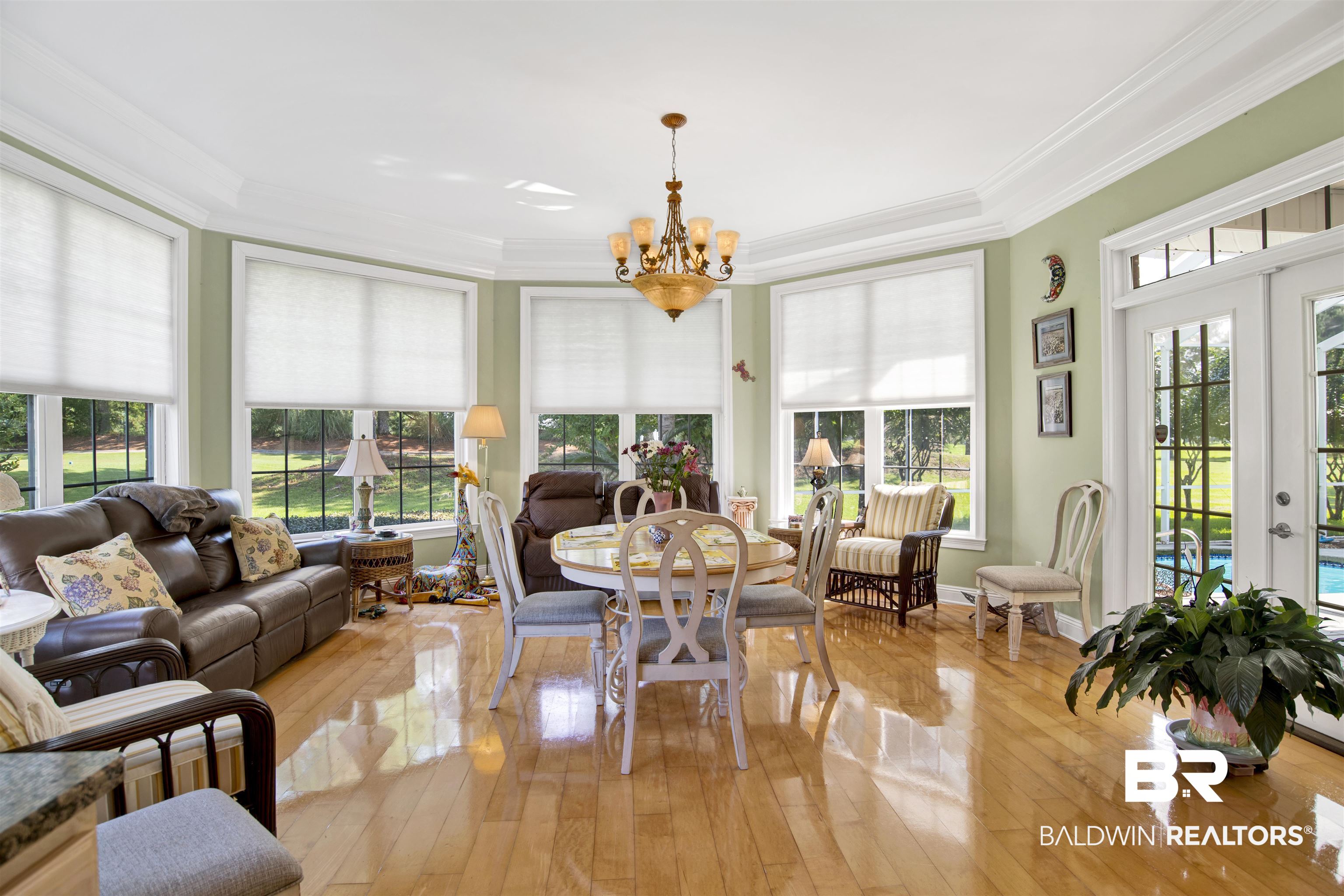 23014 Carnoustie Drive Foley, AL 36535 - Photo 28 of 49 Sunroom featuring french doors, ornamental molding, hardwood / wood-style flooring, and a chandelier