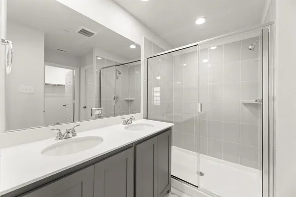 a bathroom with a shower sink vanity granite and a mirror