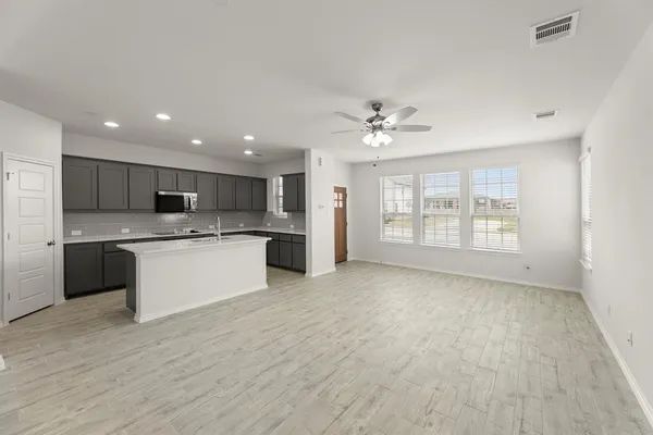 a large kitchen with kitchen island a sink stainless steel appliances and cabinets