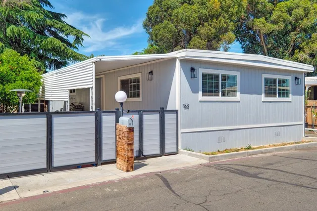 a view of a house with a garage and large tree