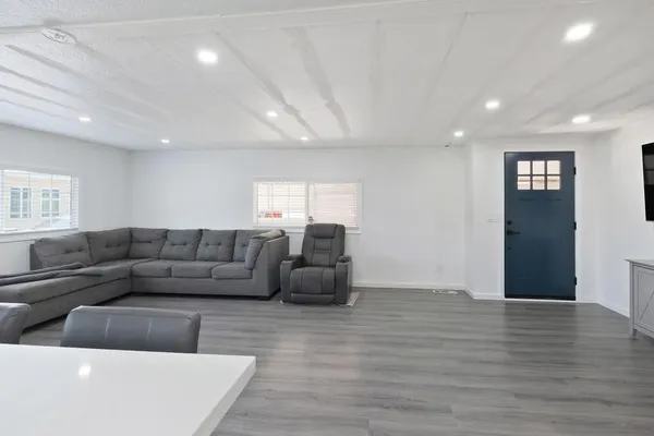 a living room with furniture and a wooden floor