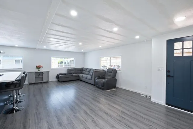 a living room with furniture and a wooden floor